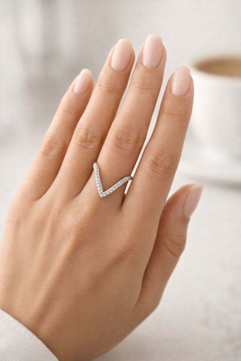 Hand wearing a diamond ring with a blurred background